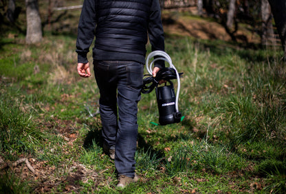Carrying the Aeromixer and its air hose across a field